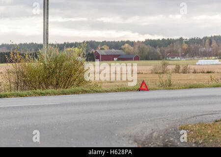 Warning Triangle on Road with field in the background. Stock Photo