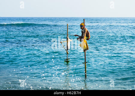 SRI LANKA - MARCH 22, 2014: Traditional fishermen fishing in traditional way near Galle in Sri Lanka. Stock Photo