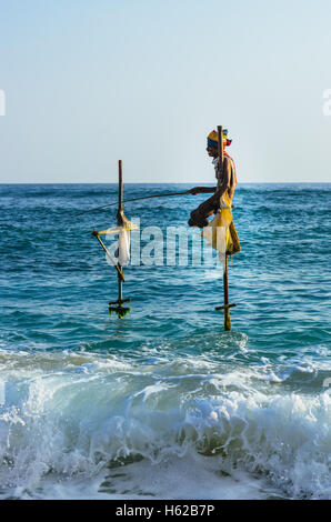 SRI LANKA - MARCH 22, 2014: Traditional fishermen fishing in traditional way near Galle in Sri Lanka. Stock Photo