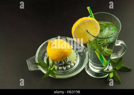 Refreshing mint and lemon. Homemade lemonade with fresh lemon and mint. Mint julep in glass on the wooden background. Stock Photo