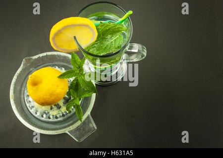 Refreshing mint and lemon. Homemade lemonade with fresh lemon and mint. Mint julep in glass on the wooden background. Stock Photo