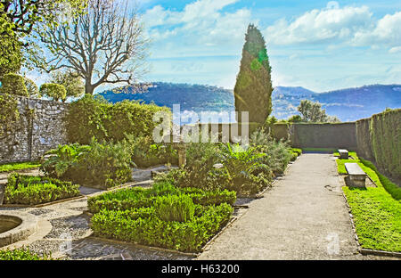 The cozy garden of the Monastery of Our Lady of Cimiez located on the top of Cimiez Hill and overlooks the foggy mountains Stock Photo