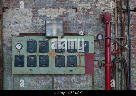 meters, pipes and hoses on brick wall Stock Photo