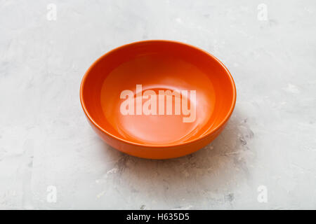 one orange bowl on gray concrete plate Stock Photo