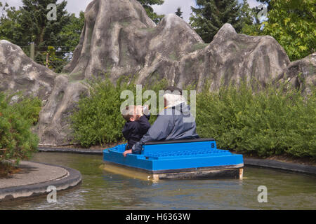Grandson photographing granddad during a boat ride in the amusement park Legoland,  Billund Denmark Stock Photo