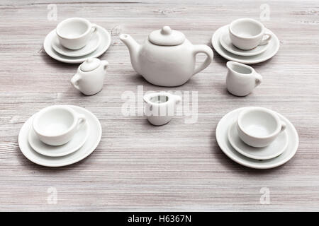 food concept - cups with saucers and tea set on gray brown table Stock Photo