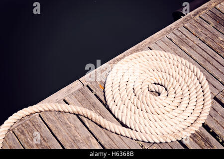 High Angle View Of Coiled Rope On Jetty Stock Photo