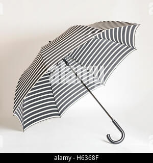 Fashion accessories - black-and-white striped umbrella. Selective focus. Stock Photo