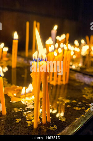 The bundle of candles, burning in the tray, full of sand and water, Yerevan, Armenia. Stock Photo