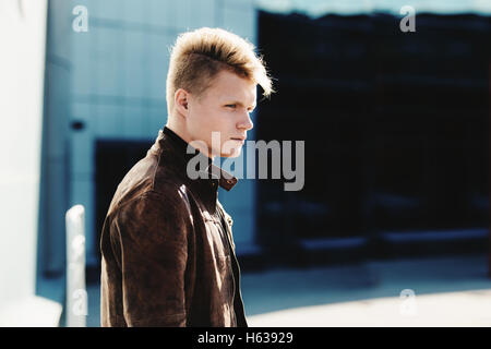 Young handsome stylish man in brown jacket in autumn time outdoor in casual style Stock Photo