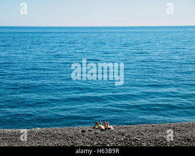 A young couple enjoys the summer at the beach of Faja dos Padres on the Portuguese island of Madeira Stock Photo