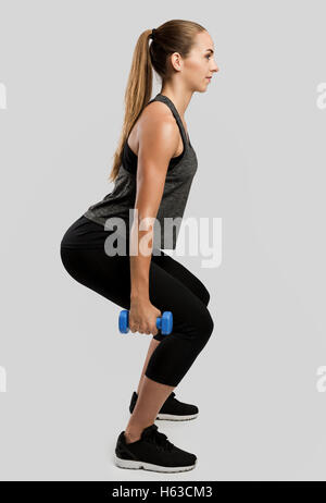 Young fitness woman making exercises with dumbbells Stock Photo