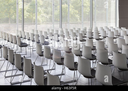 Empty white chairs in contemporary conference hall with Stock Photo