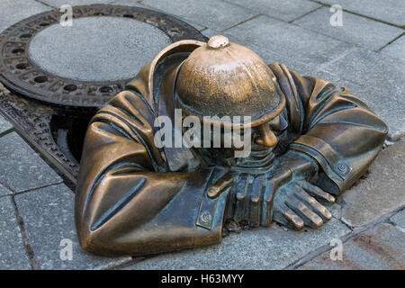 A bronze statue representing a street worker emerging from a manhole. Bratislava, Slovakia.