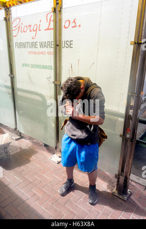 San Francisco, CA, USA, Intravenious Drug User, CHecking Abscessed Arm in Downtown Bus Shelter, Street Scenes, Skid Row,  low income urban usa Stock Photo