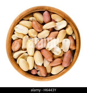 Shelled peanuts in wooden bowl on white background. Dry roasted Arachis hypogaea, also called groundnut and goober. Stock Photo