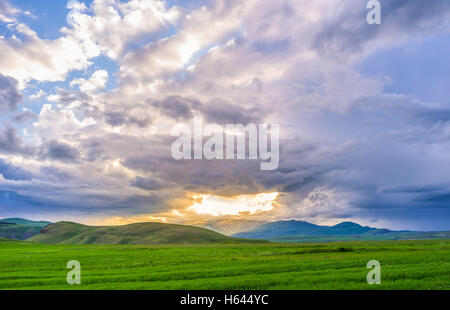 The bright hole in the grey cloudy sky looks like gateway to heaven, open over the highlands, Syunic Province, Armenia. Stock Photo