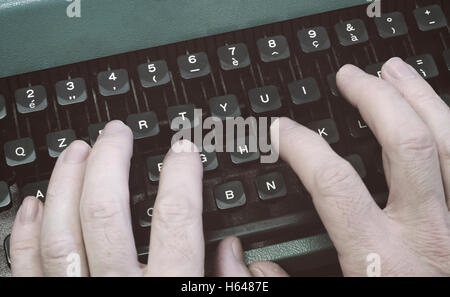 hands typing the keys on an old typewriter. Stock Photo