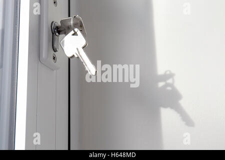 Key in window rim lock of double glazed unit for house security purposes Stock Photo