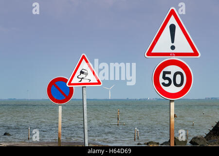 together of road signs for warning next to sea Stock Photo