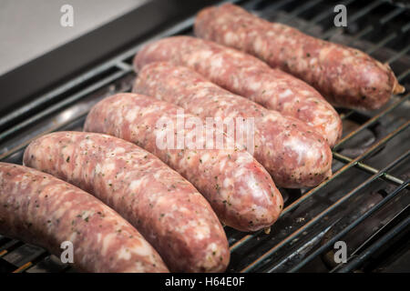 sausage cooking herbs on an electric bbq during summer Stock Photo