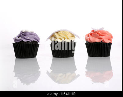 Three Cup Cakes Isolate on Reflective White Background Stock Photo
