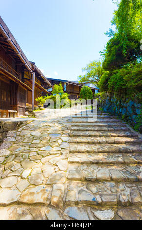Inlaid stone road alongside Japanese style traditional wooden houses in Tsumago village on the historic Nakasendo route in Japan Stock Photo