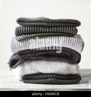 Stack of gray woolen knitted sweaters on a white background Stock Photo