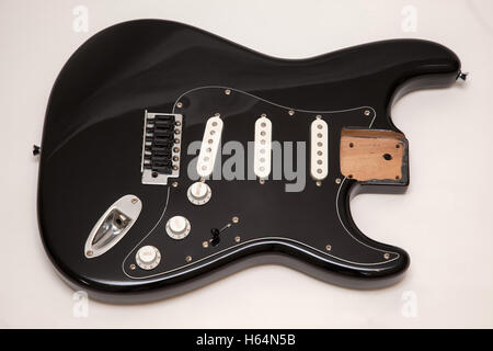 A black fender stratocaster copy electric guitar body, neck removed, tremolo arm removed Stock Photo