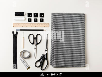Everything for sewing in black and white. Fabric and thread, zipper and buttons, scissors and centimeter, pencil and ruler. Stock Photo
