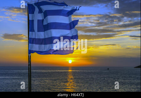 Tatty tired, torn, Greek flag fluttering at sunset, Stock Photo