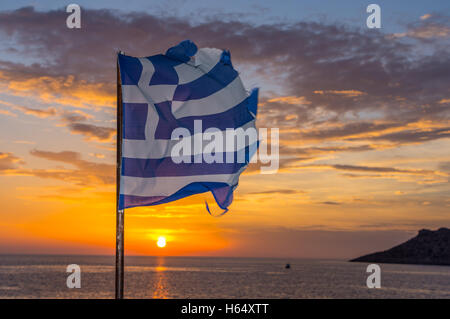 Tatty tired, torn, Greek flag fluttering at sunset, Stock Photo