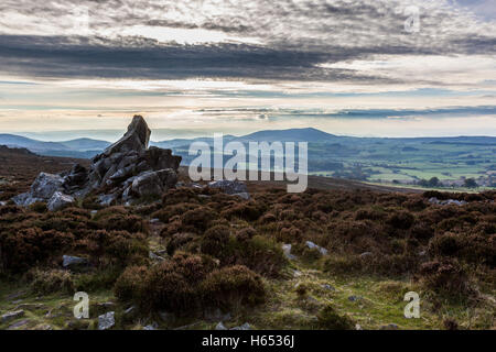 A rocky outcrop on the Stiperstones ridge near Snailbech, Shropshire, with Corndon Hill in the distance. Stock Photo