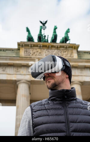 Man wearing Virtual Reality (VR) goggles in front of Brandenburg Gate  in Berlin, Germany Stock Photo