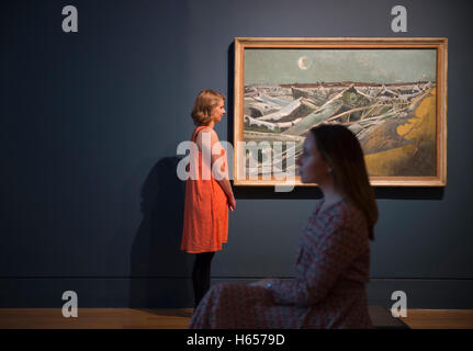 Tate Britain, London, UK. 24th October, 2016. The largest exhibition of the works of Paul Nash for a generation opens on 26 October - 5 March 2017. Renowned as a war artist in both the 1st and 2nd World Wars, the exhibition reveals his work, from his earliest drawings through to his final visionary landscapes. Photo: Paul Nash 1889-1946. Totes Meer (Dead Sea), 1940-1. Oil on Canvas. Tate. Presented by the War Advisory Committee 1946, posed with members of Gallery staff. Credit:  artsimages/Alamy Live News. Stock Photo