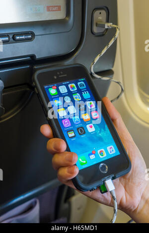 Charging mobile phone onboard an aircraft Stock Photo