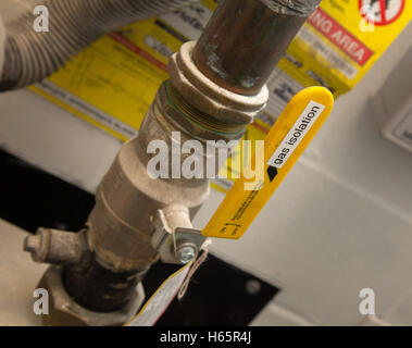 A gas isolation valve, bright yellow, with warning signs Stock Photo