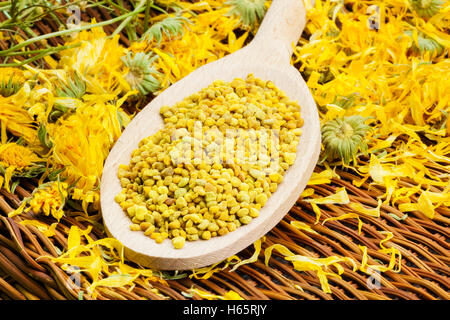 Bee pollen grains with dry yellow calendula around Stock Photo