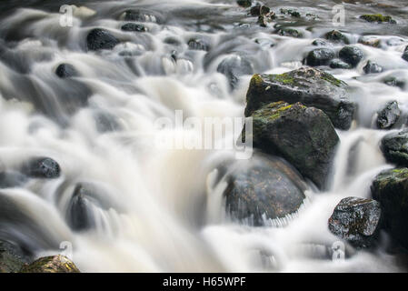 Detail of water flowing over boulders in the River Garry in Glengarry Forest, Lochaber, Scottish Highlands, Scotland Stock Photo