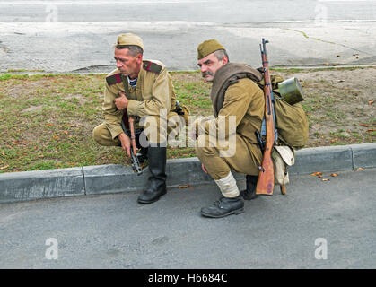Dnepropetrovsk, Ukraine - September 14, 2013: Group of unidentified re-enactors dressed as Soviet soldiers in greatcoat resting Stock Photo