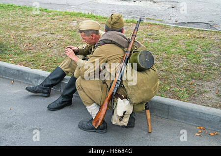 Dnepropetrovsk, Ukraine - September 14, 2013: Group of unidentified re-enactors dressed as Soviet soldiers in greatcoat resting Stock Photo