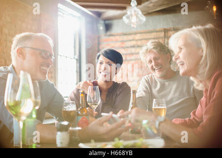 Couples dining and using cell phone at restaurant table Stock Photo