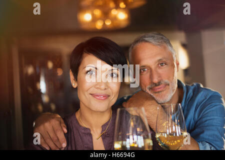 Portrait confident couple drinking white wine in bar Stock Photo