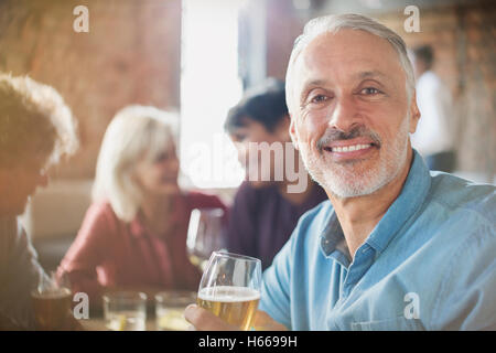 Portrait confident man drinking white wine with friends at restaurant table Stock Photo