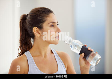 Woman drinking water post workout Stock Photo