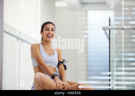 Portrait laughing woman listening to music with headphones post workout Stock Photo