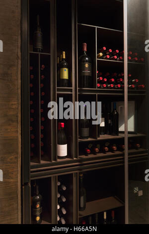 Wine bottles organized on wooden shelves in wine library Stock Photo