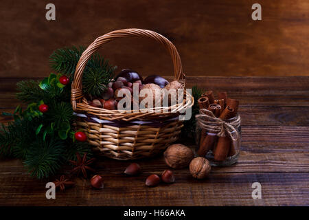 Assorted nuts and spices in a basket,Walnut,almond, peanut, hazelnut, cinnamon sticks,chestnuts,star anise Autumn harvest Stock Photo