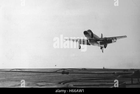 Royal Navy Fleet Air Arm Supermarine Attacker aircraft approached the flight deck of aircraft carrier HMS Eagle. The Attacker was the first jet aircraft to see service with the Fleet Air Arm. Stock Photo