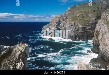 Couple on the cliff overlooking Marble Arch, Horn Head, County Donegal, Ireland. Stock Photo